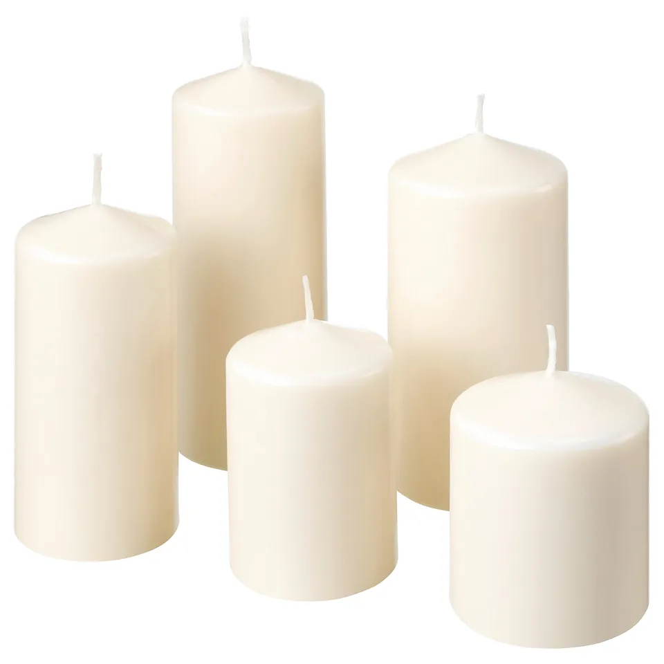 Six unscented white candles of varying heights, cylindrical shape, smooth texture, and simple design arranged together.