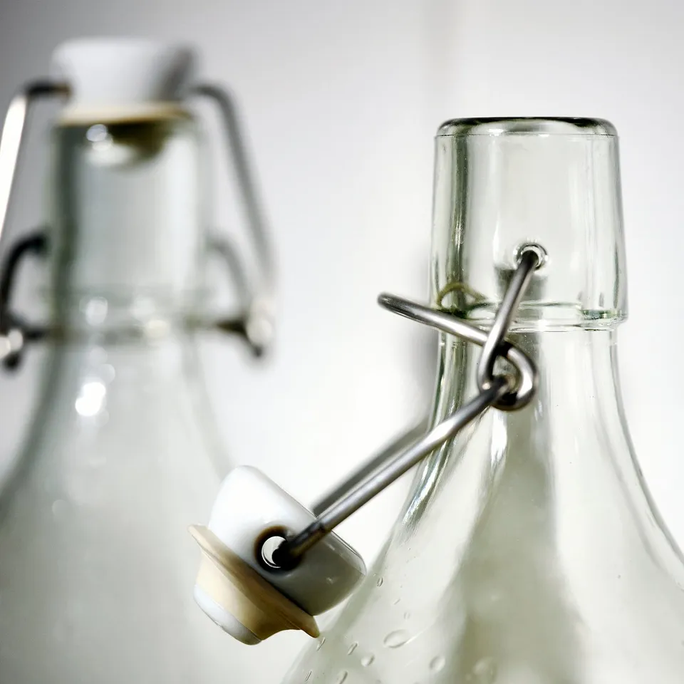 Clear glass bottles with white lids and metal clasps, showcasing an airtight seal for secure storage.
