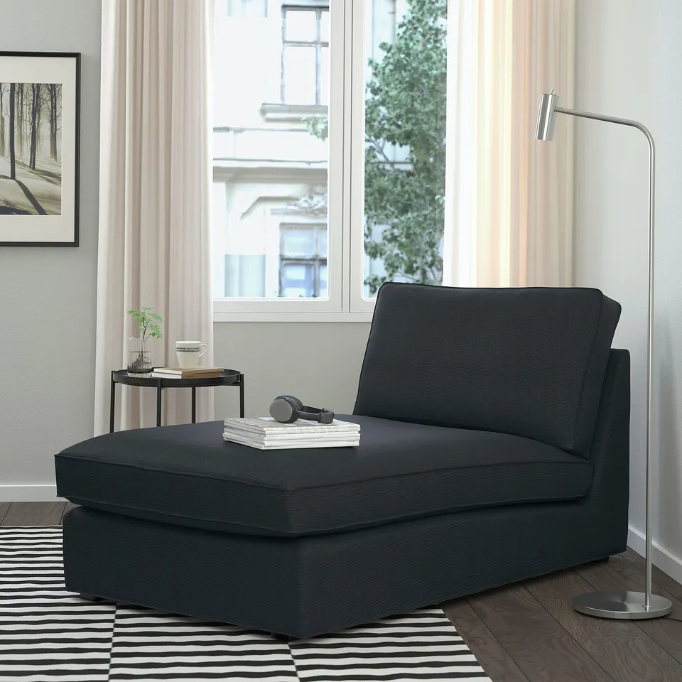 Modern grey KIVIK chaise longue, sleek & comfy, fits well near window, with lamp & rug.
