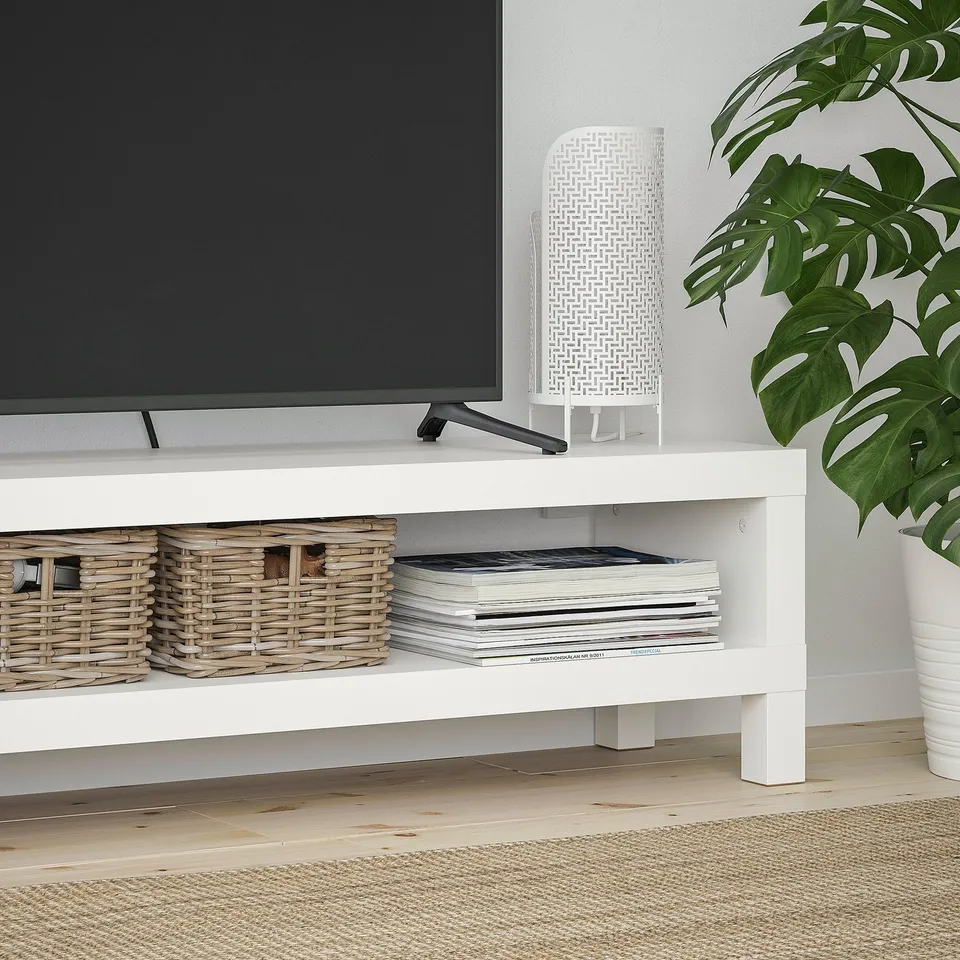 White tv stand with wicker baskets and books. Perfect for organising and storing media.