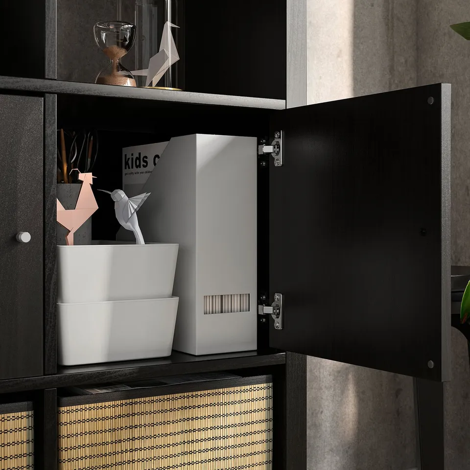Open KALLAX shelving unit displaying storage boxes and decorative items, showcasing its versatility and organisational potential.