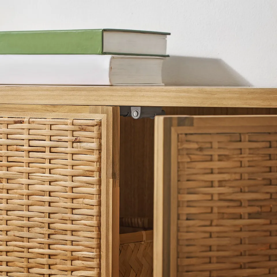 Rattan cabinet with green book, sturdy design, natural finish.