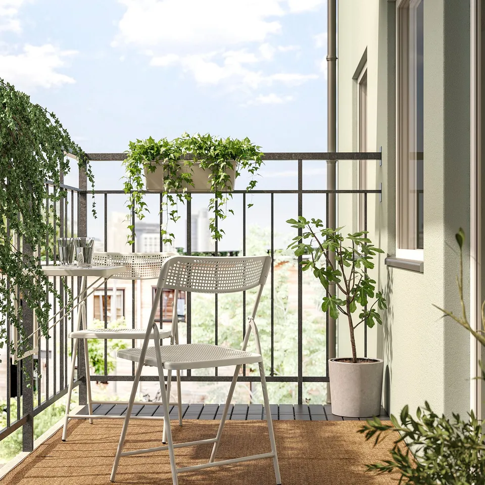 Balcony with TORPARÖ table & chairs, plants, rug, large windows