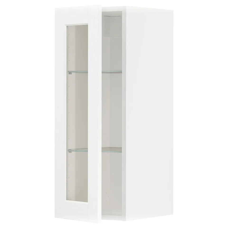 A white ikea METOD wall cabinet with glass doors, hiding stored items.