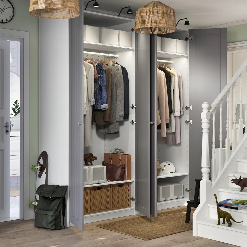 A well-organized entryway closet with coats, bags, and accessories. It open and closed storage, lighting, and is fixed to the wall for stability.