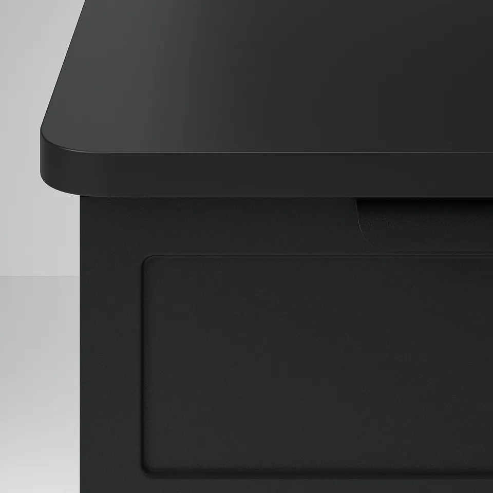 Modern black bedside table with sleek, rounded edges and a flip-open door for hidden storage.