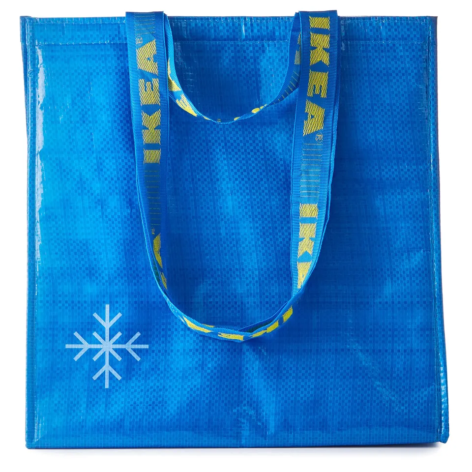 Blue reusable tote bag with yellow straps. A white snowflake design, made from recycled material.