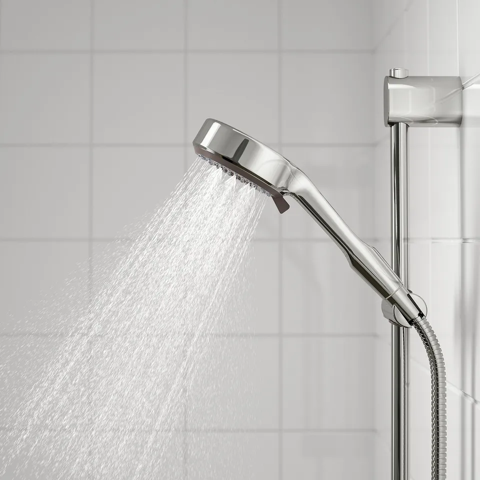 Handheld shower head with full spray function. Chrome finish. Water flows from multiple nozzles. Connected to a slide bar holder.