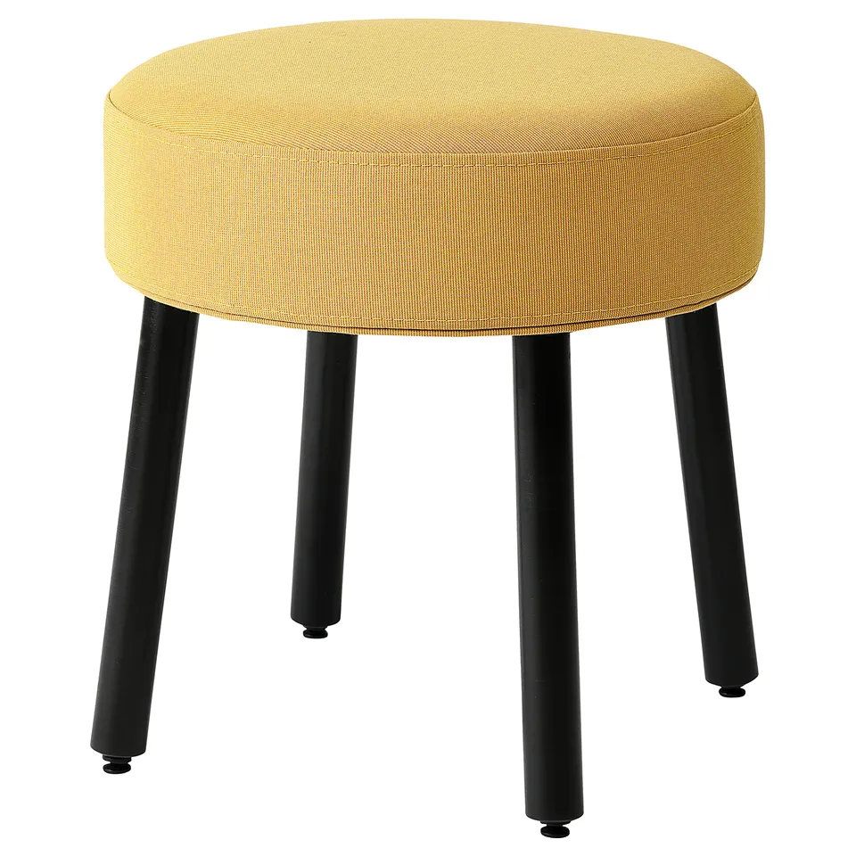Yellow MÖRTFORS stool, round upholstered seat on black legs.