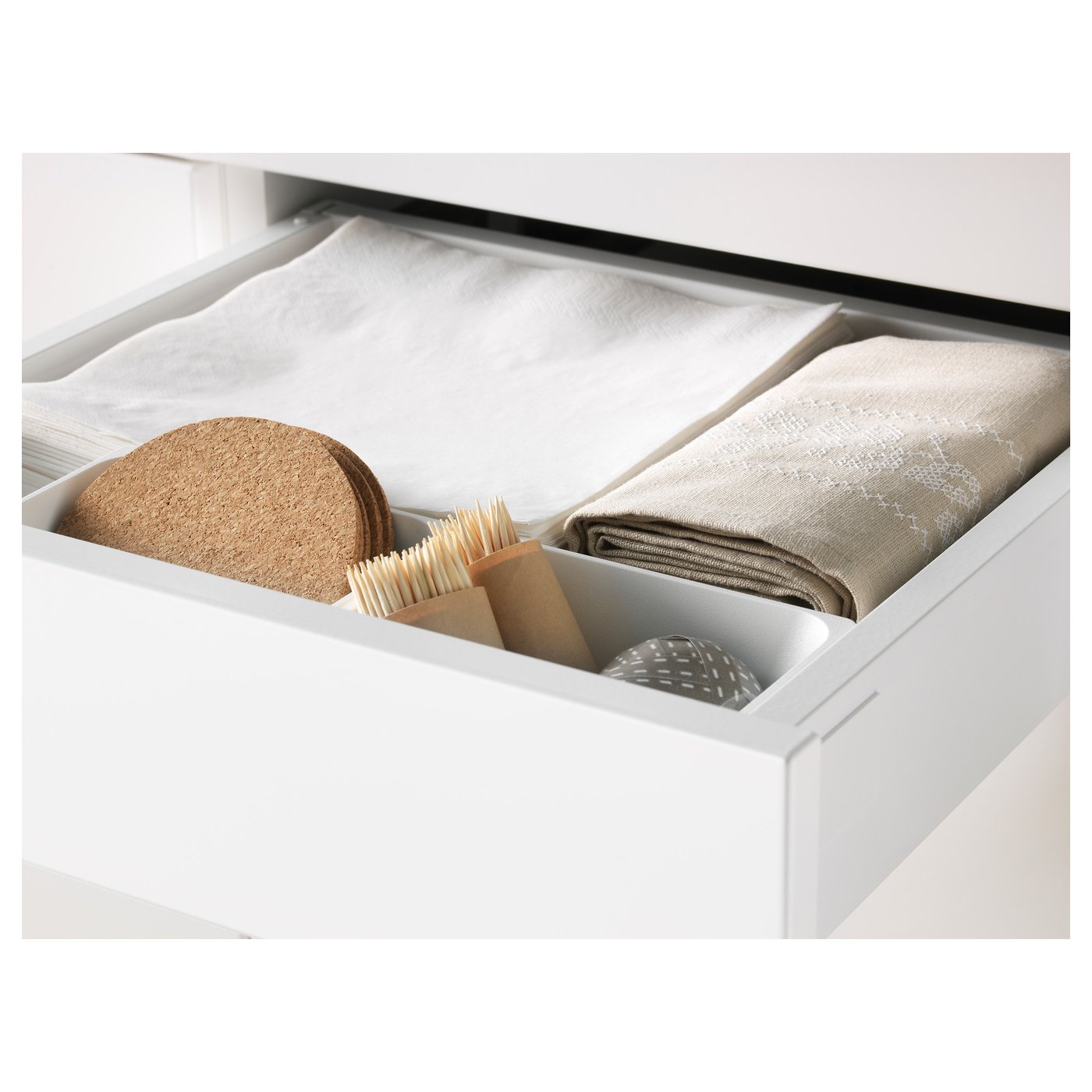 Open kitchen drawer showing folded towels and cleaning tools, demonstrating storage and organisation.