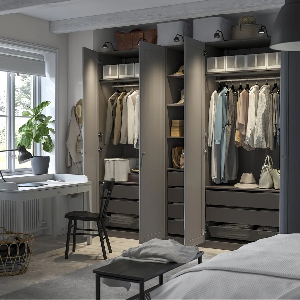 Bedroom with large PAX wardrobes displaying organised clothes, shelves, and storage boxes.
