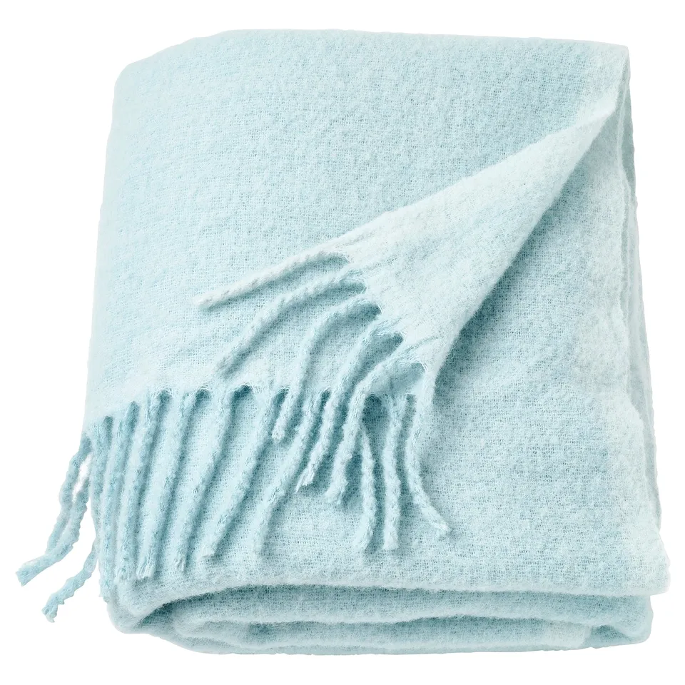 Light blue, soft recycled polyester throw with fringe detail, folded neatly.