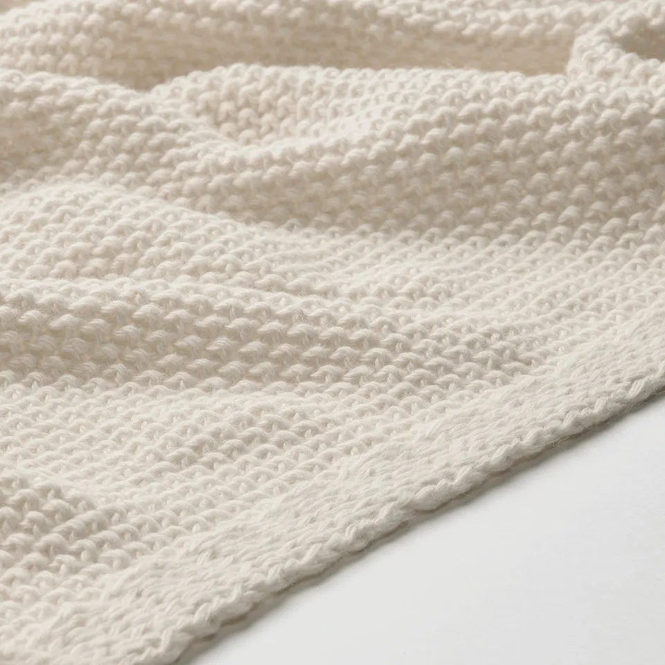 Close-up of soft, textured knit blanket, showcasing its dense, recycled material and cosy texture.