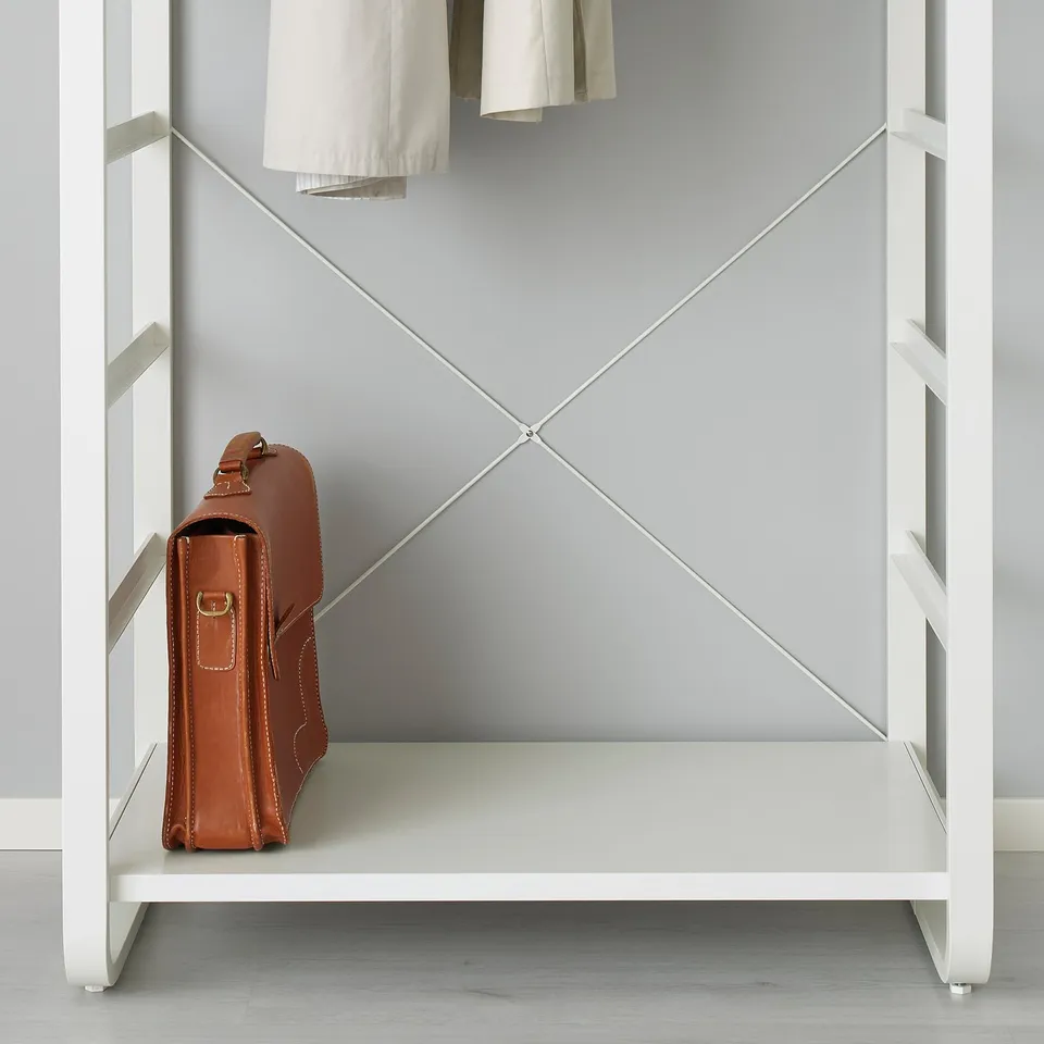 Brown leather bag sitting on white shelf inside open white closet.