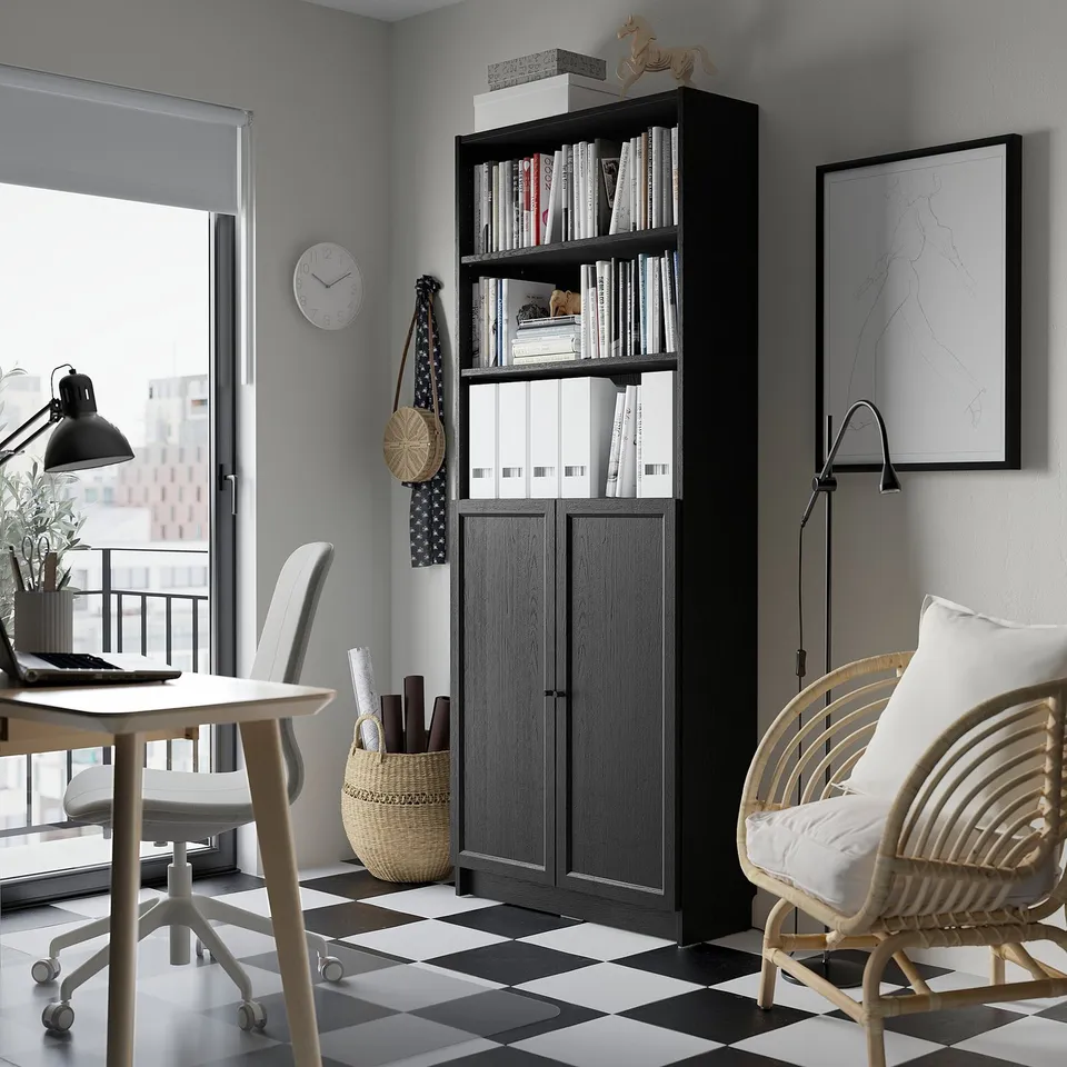 Modern home office with BILLY bookcase, desk, wicker chair, lamp, and chequered floor.
