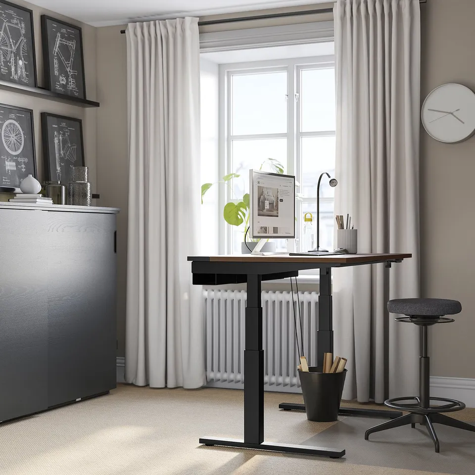 Home office with MITTZON desk, large window, decor.