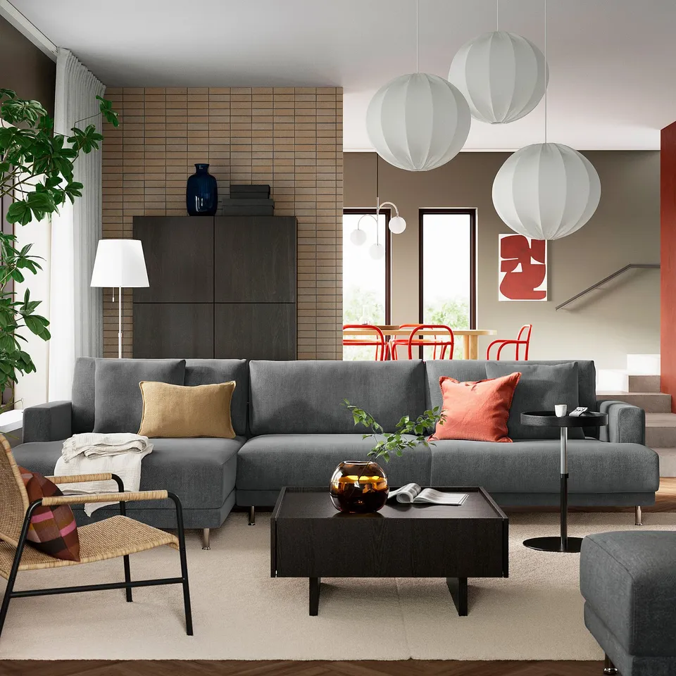 Modern living room with grey UPPÅKRA sofa, wooden table, pendant lamps, rattan chair.