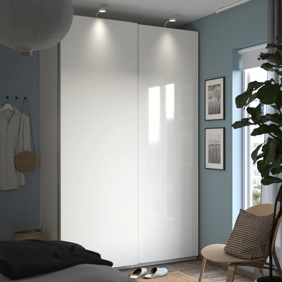 Modern bedroom with sliding doors, blue walls, bed, plant, daylight