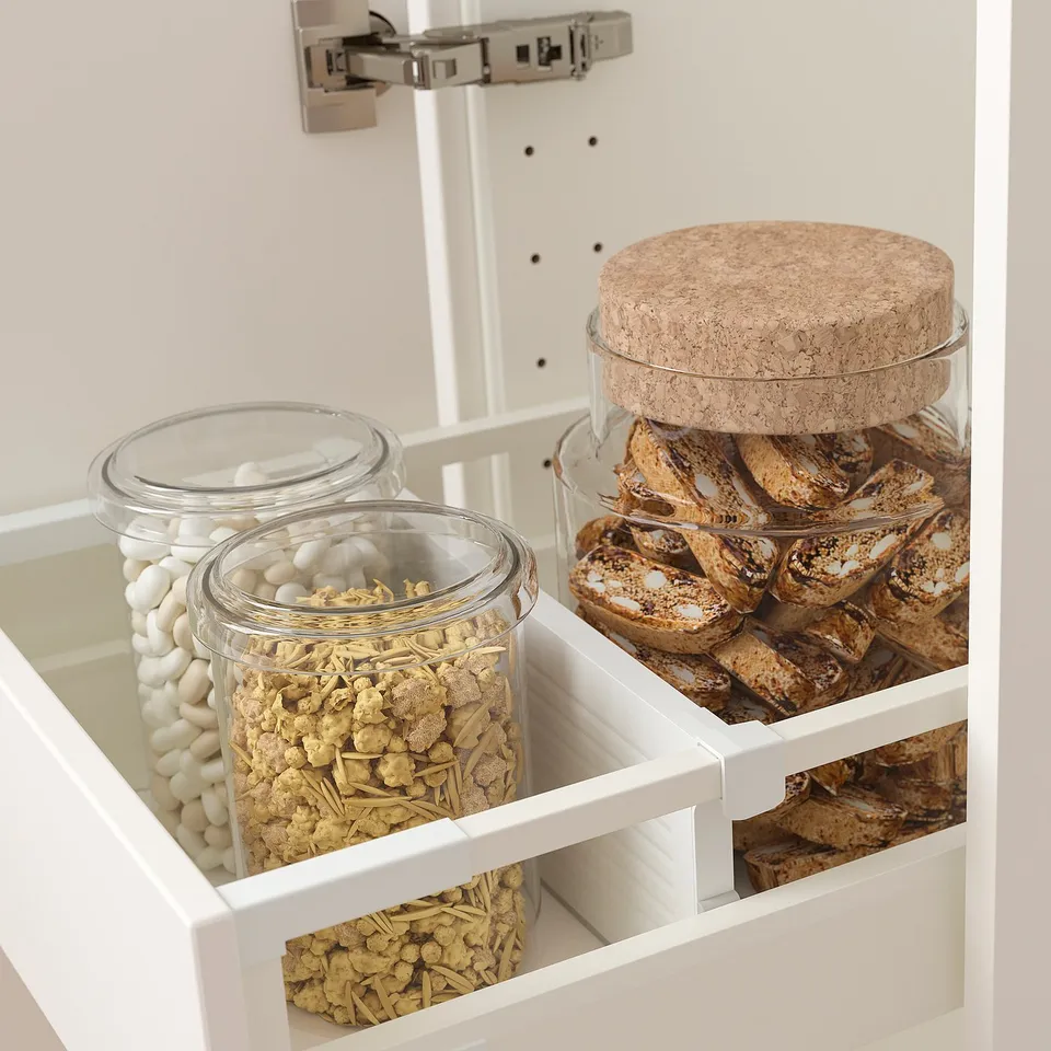 Glass jars in drawer divider. Left jar has marshmallows, centre jar has granola. Right has biscotti. Cork lid on right jar.
