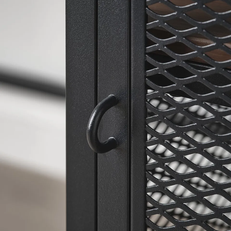 Black metal cabinet with textured surface and curved door handle. Industrial design, sturdy construction.