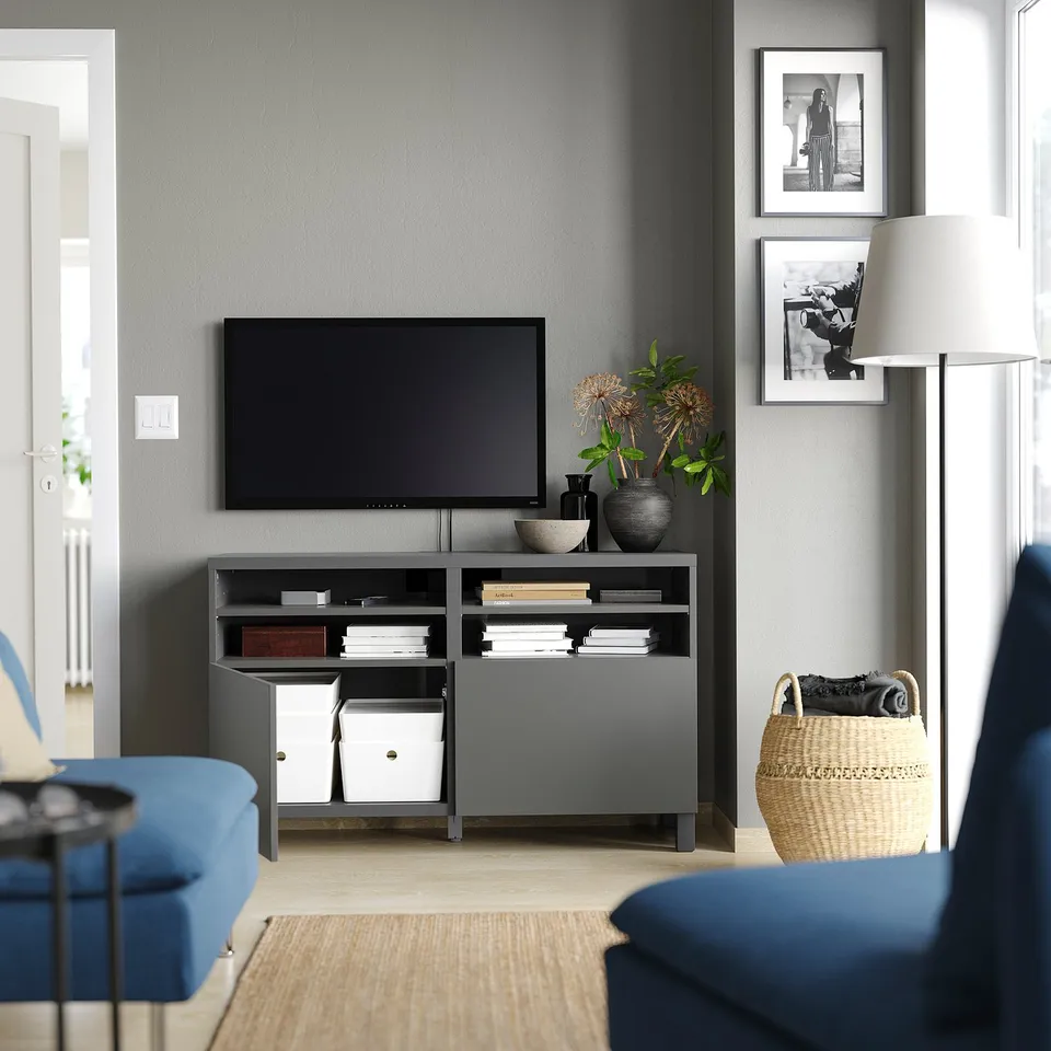 Modern living room with BESTÅ tv stand, blue armchairs, and decor.
