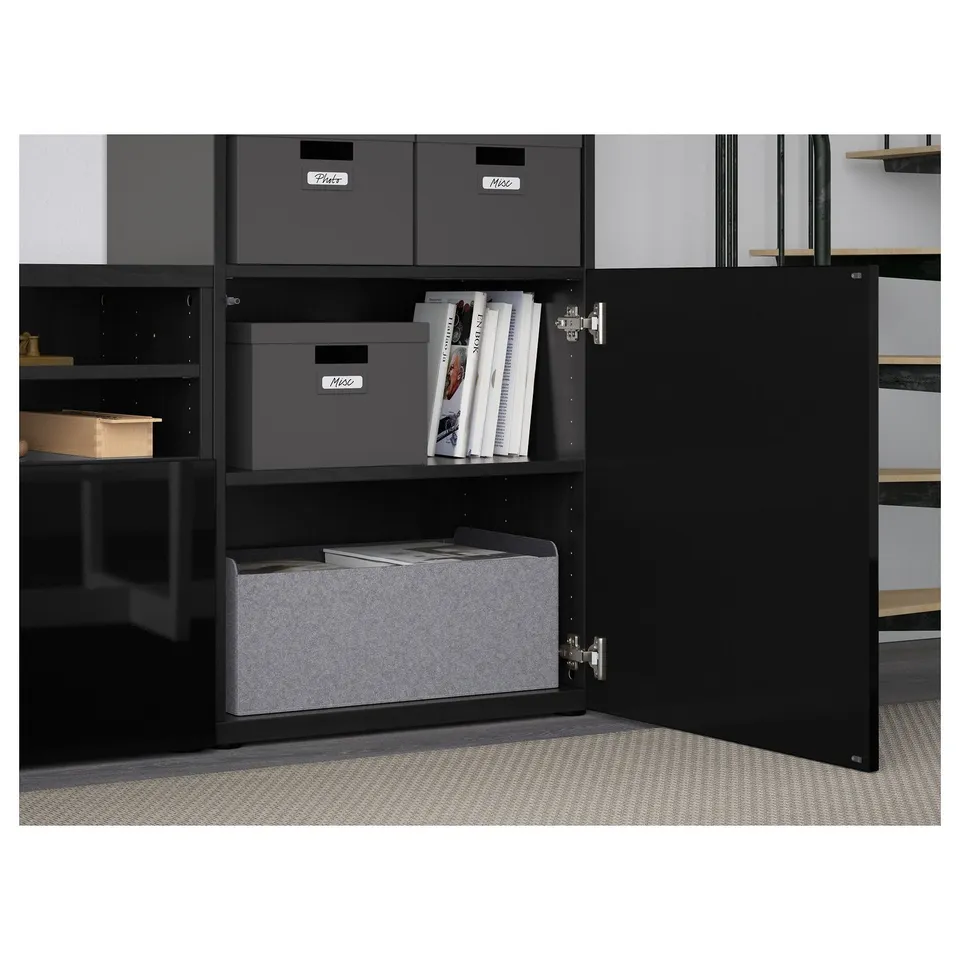 Open BESTÅ cabinet showing adjustable shelves with storage boxes and organised magazines.