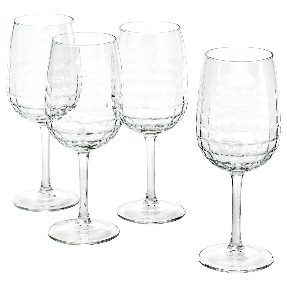Four clear, faceted wine glasses from the FRÖJDA collection, standing neatly, perfect for elegant occasions.
