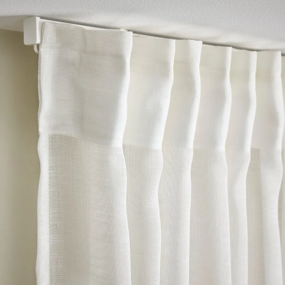 Curtain close-up showing sheer fabric with pleats and heading tape for easy hanging.