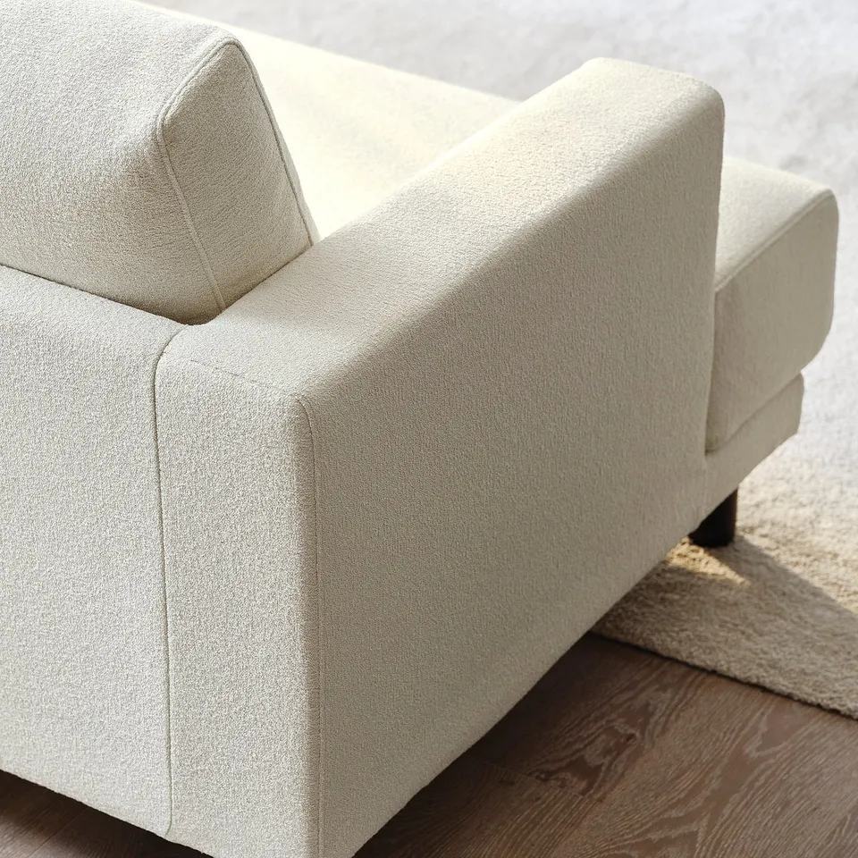 Modern cream-colored sofa with plush cushions and clean lines.