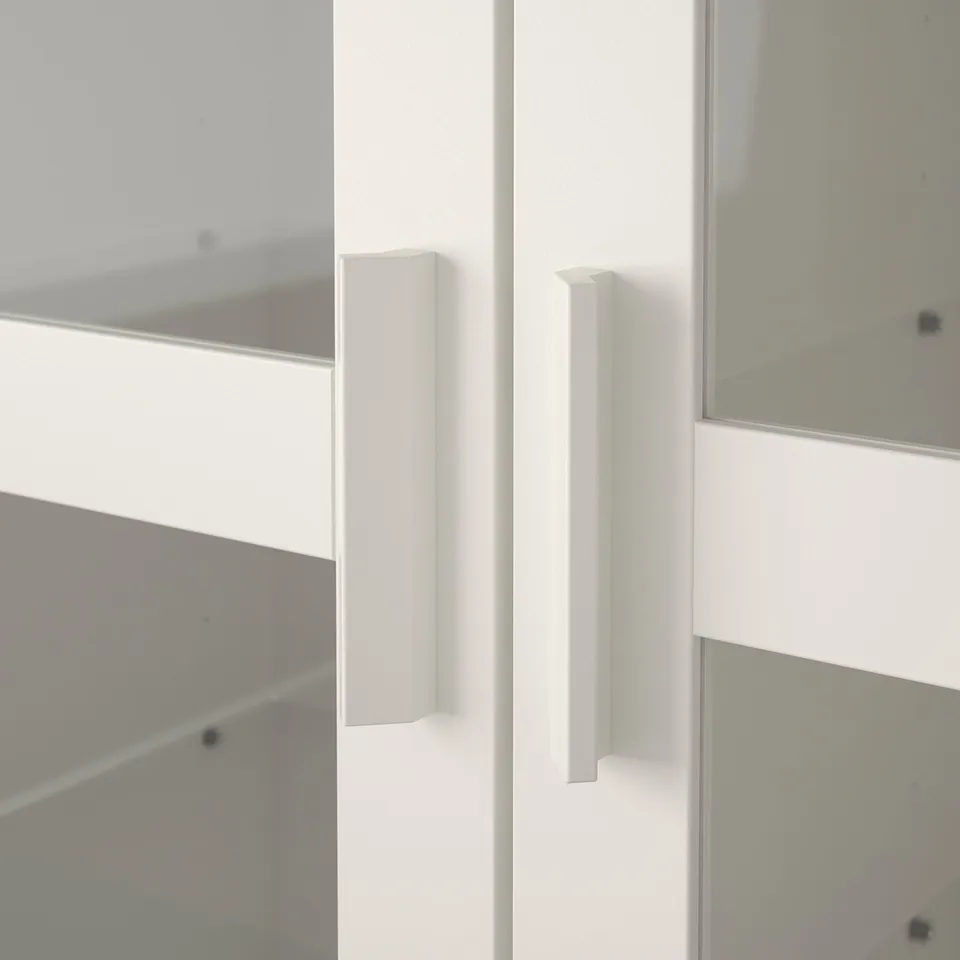 White cabinet with modern, vertical handles, featuring sleek, closed shelves.