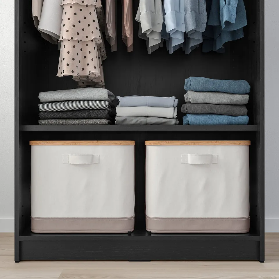 Closet shelf with folded clothes and storage bins. Safety attached.