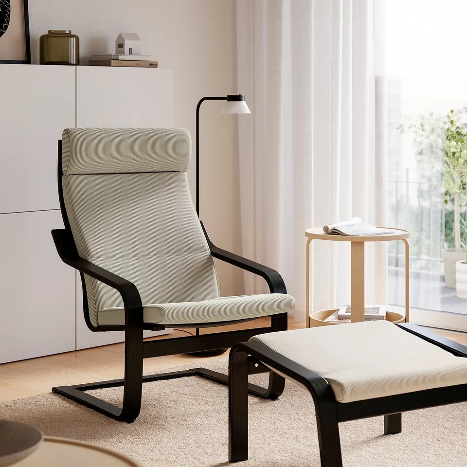 Modern living room with POÄNG chair, light wood lamps, and bookshelf.