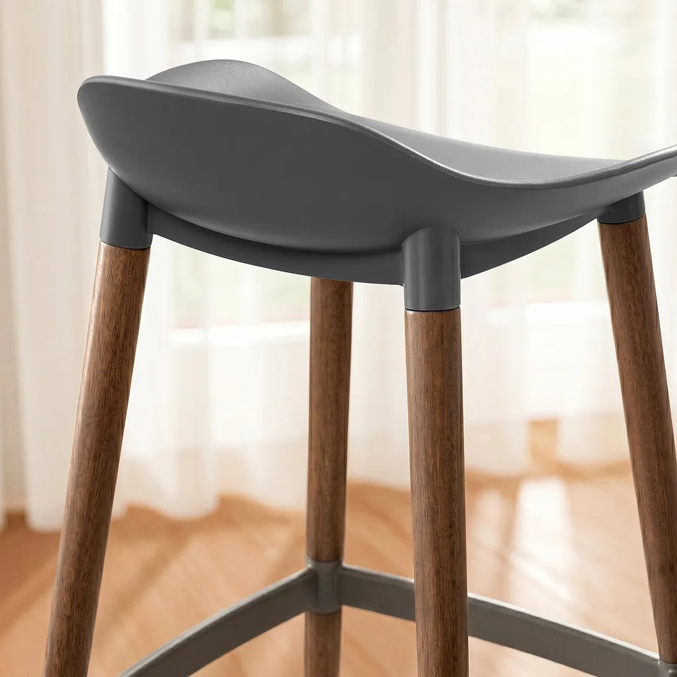 Modern bar stool with sleek, curved seat and sturdy wooden legs, designed for comfort and style.