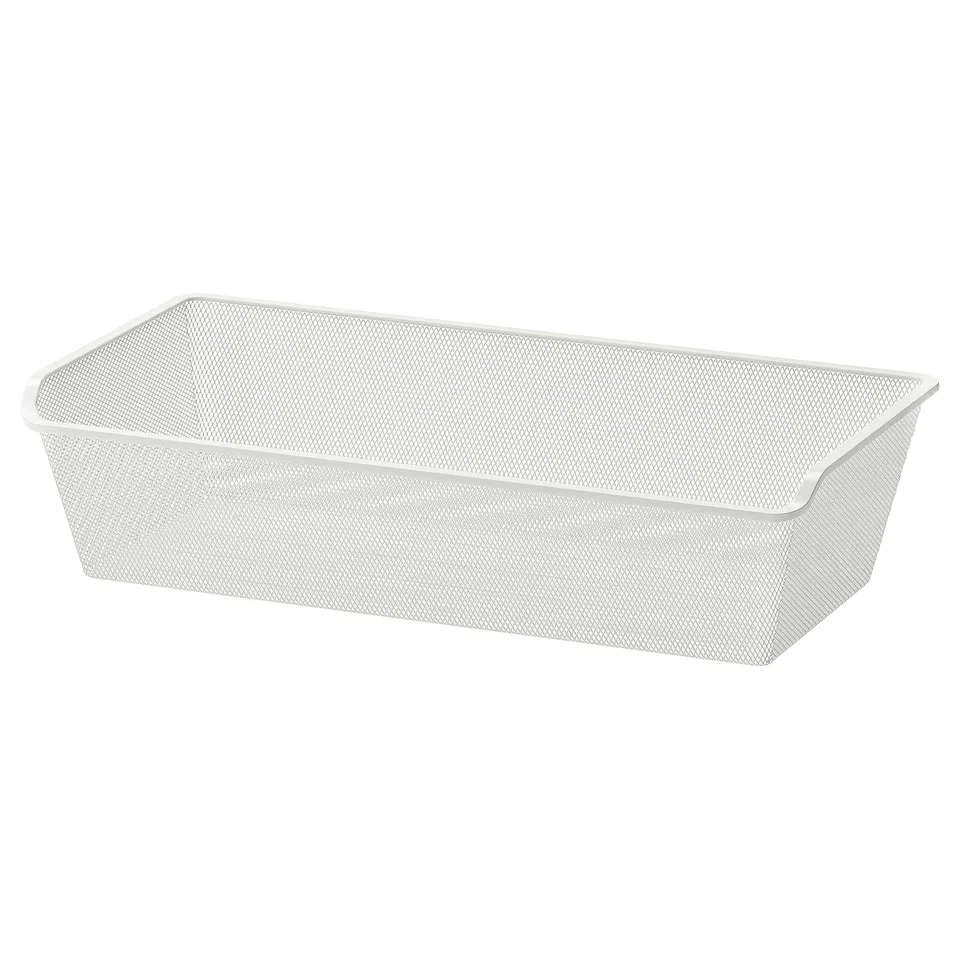 A white rectangular mesh storage basket by KOMPLEMENT, made of steel with a powder-coated finish, designed for organising clothes and accessories.