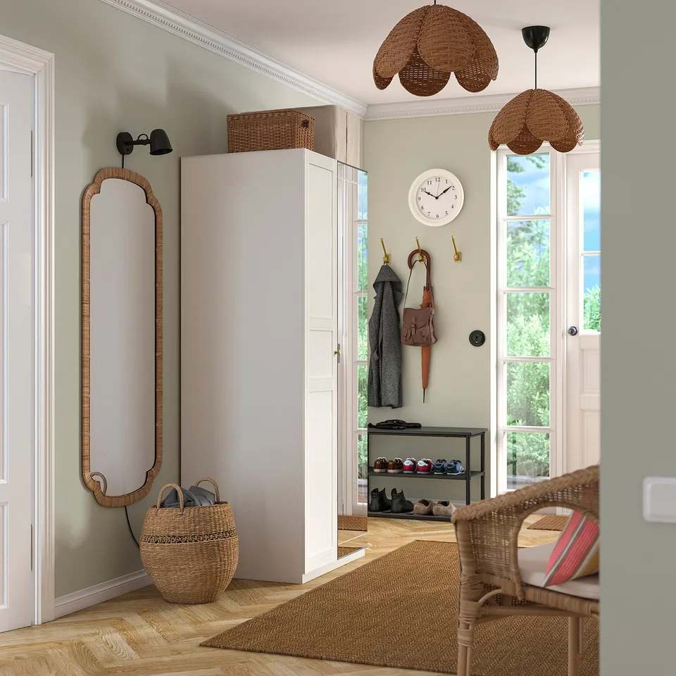 Small entryway: wardrobe, wicker chair, baskets, pendant lights, mirror, wall clock, coat hooks.