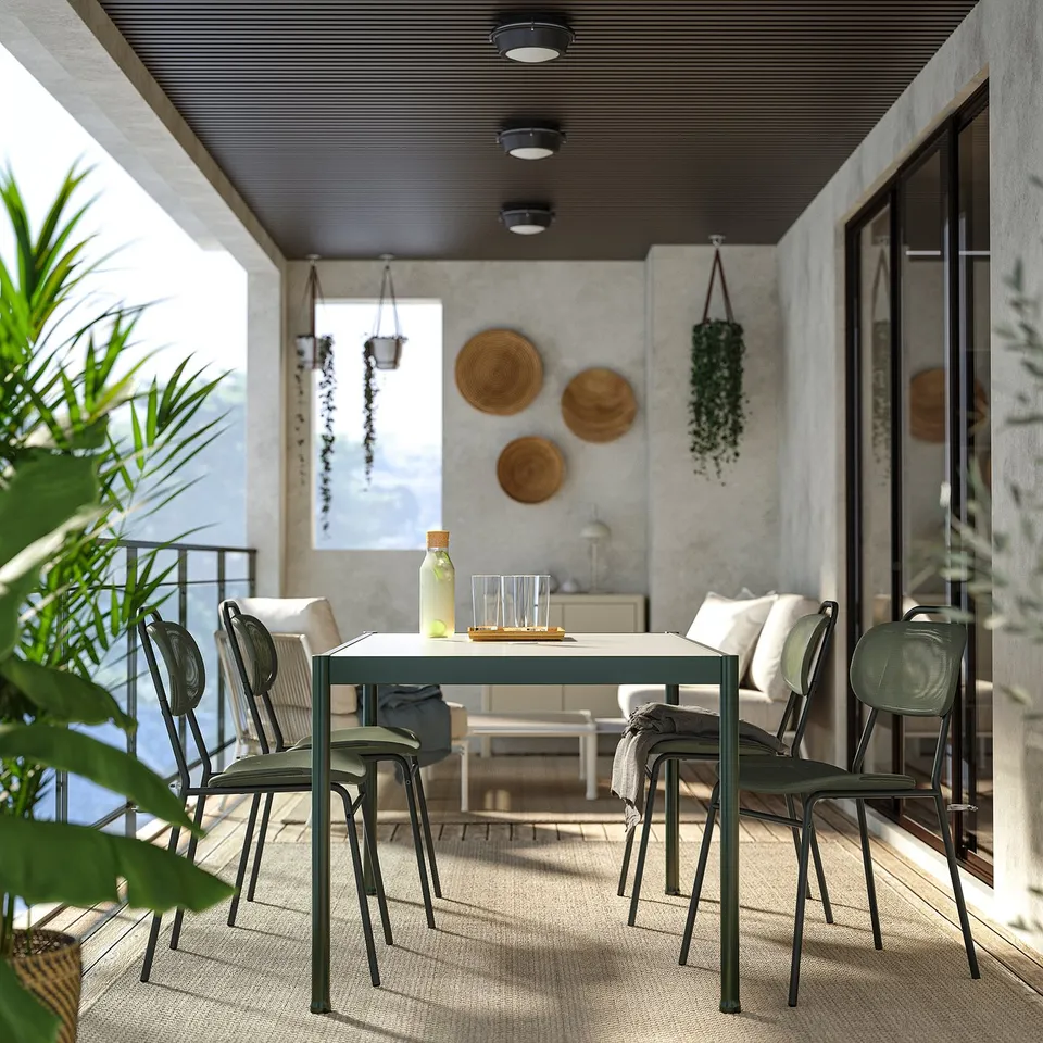 Outdoor dining set with table, chairs, sofa, plants.