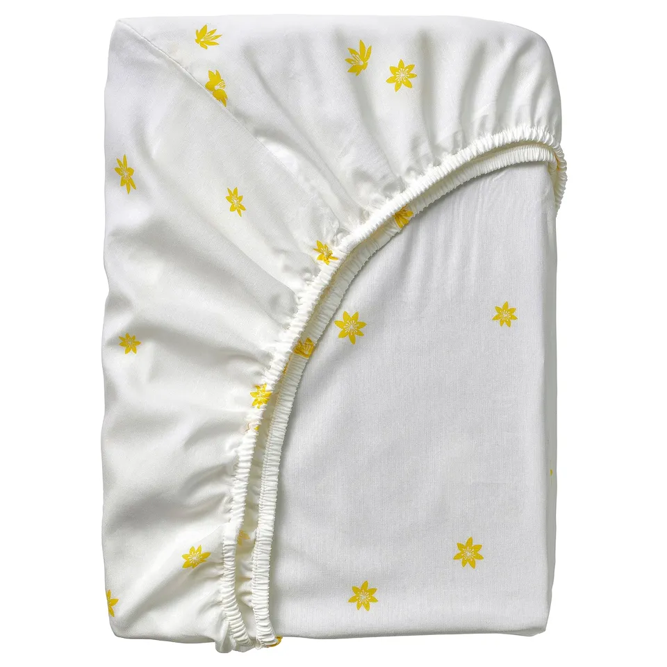 White crib sheet, yellow flower print, cotton blend, fitted design.