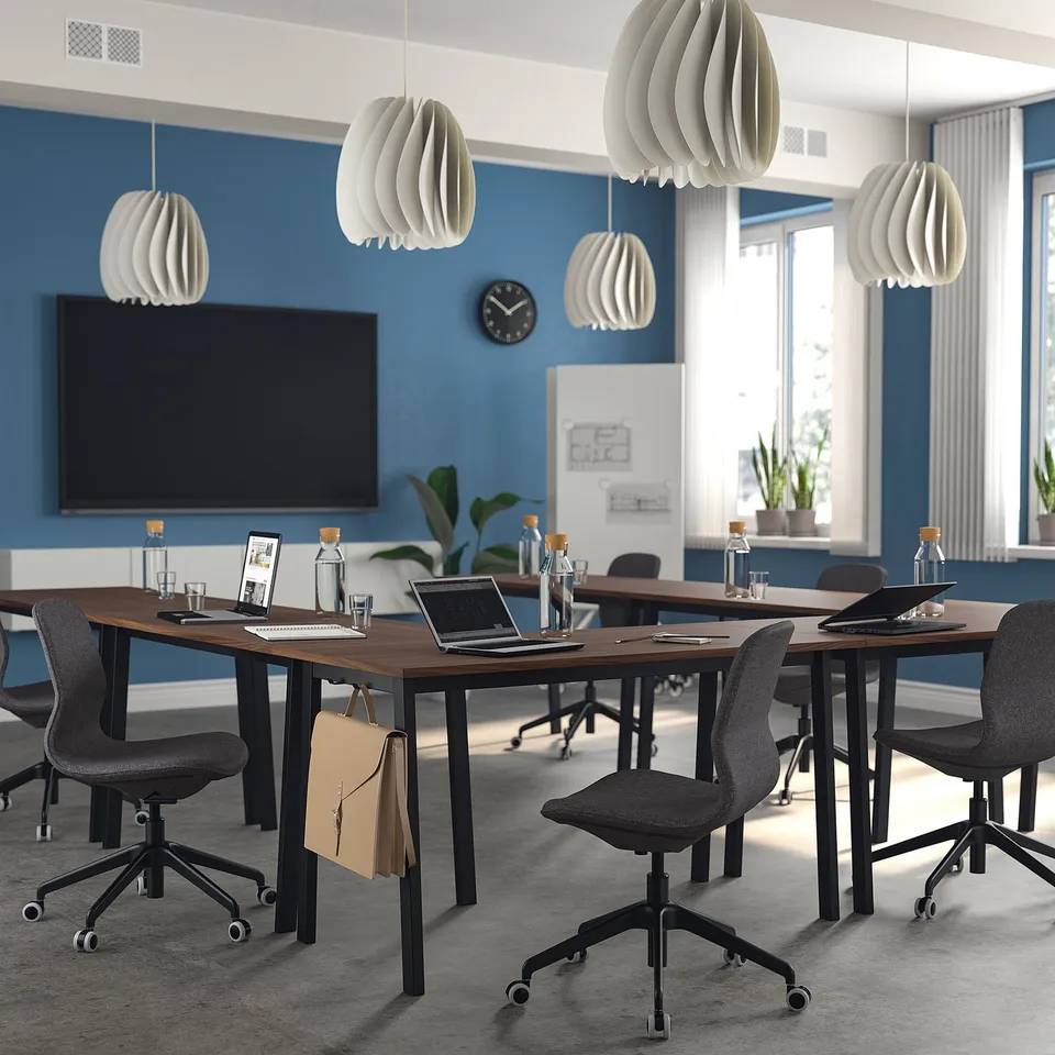 Modern blue conference room with MITTZON walnut tables, black chairs, white lights, laptops, and a wall screen.