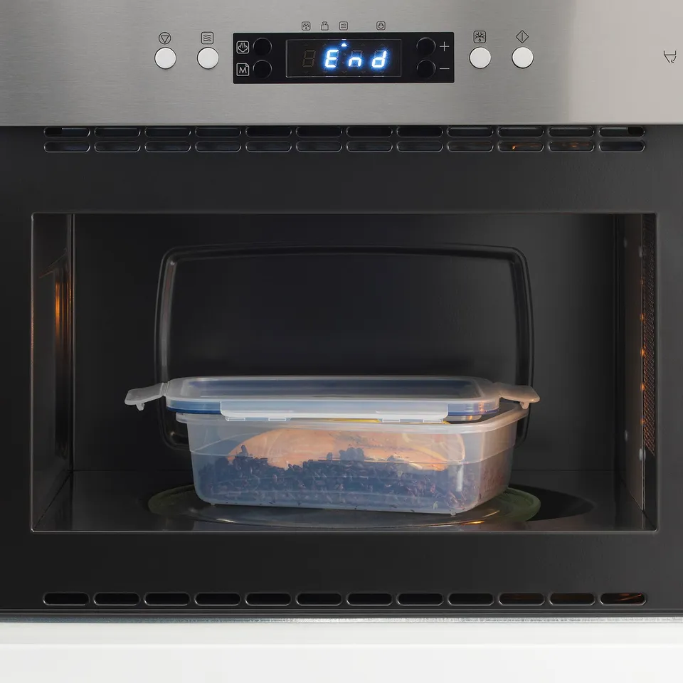 Clear plastic container with snap-lock lid in microwave, heating food.
