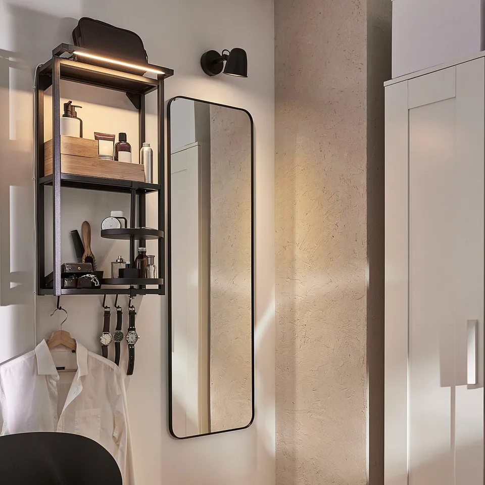 Modern dressing area with SKYDRAG led shelf lights, mirror, chair, and wardrobe.