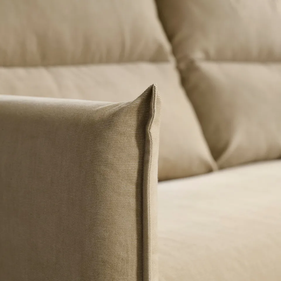 Beige sofa close-up; soft, smooth fabric, well-cushioned, high backrest.