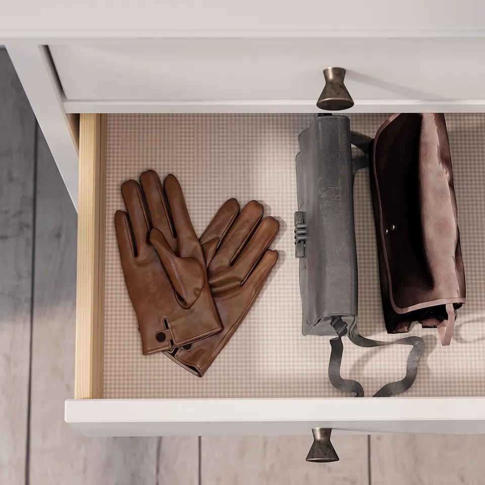 Brown leather gloves hang on white shelf with umbrella.