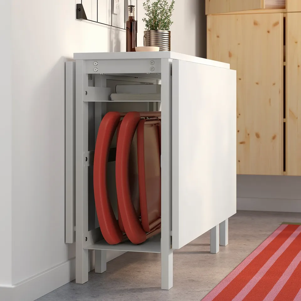 Open white cabinet holds red folding chairs neatly. Perfect for space-saving.
