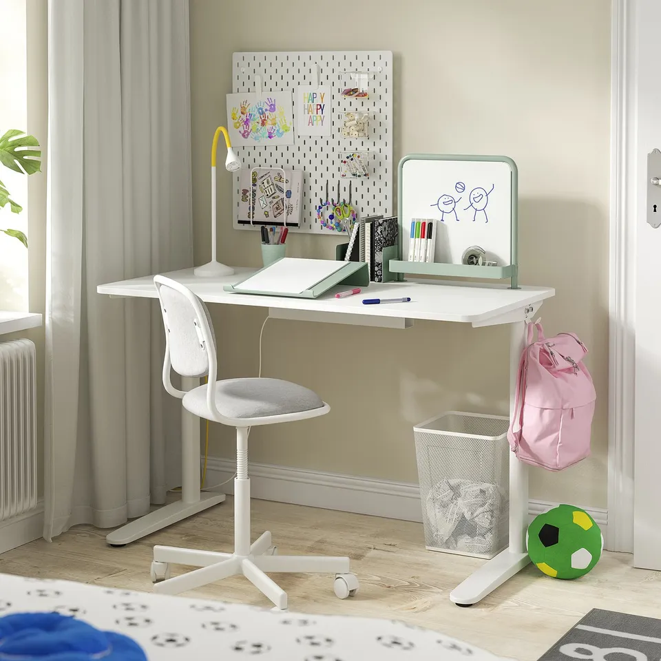 Childs study area with white desk, chair, and storage.