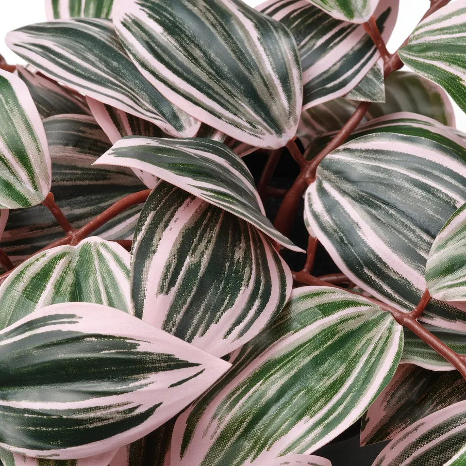 Artificial leaves with green and white stripes on pinkish-green background, showing high-quality craftsmanship.