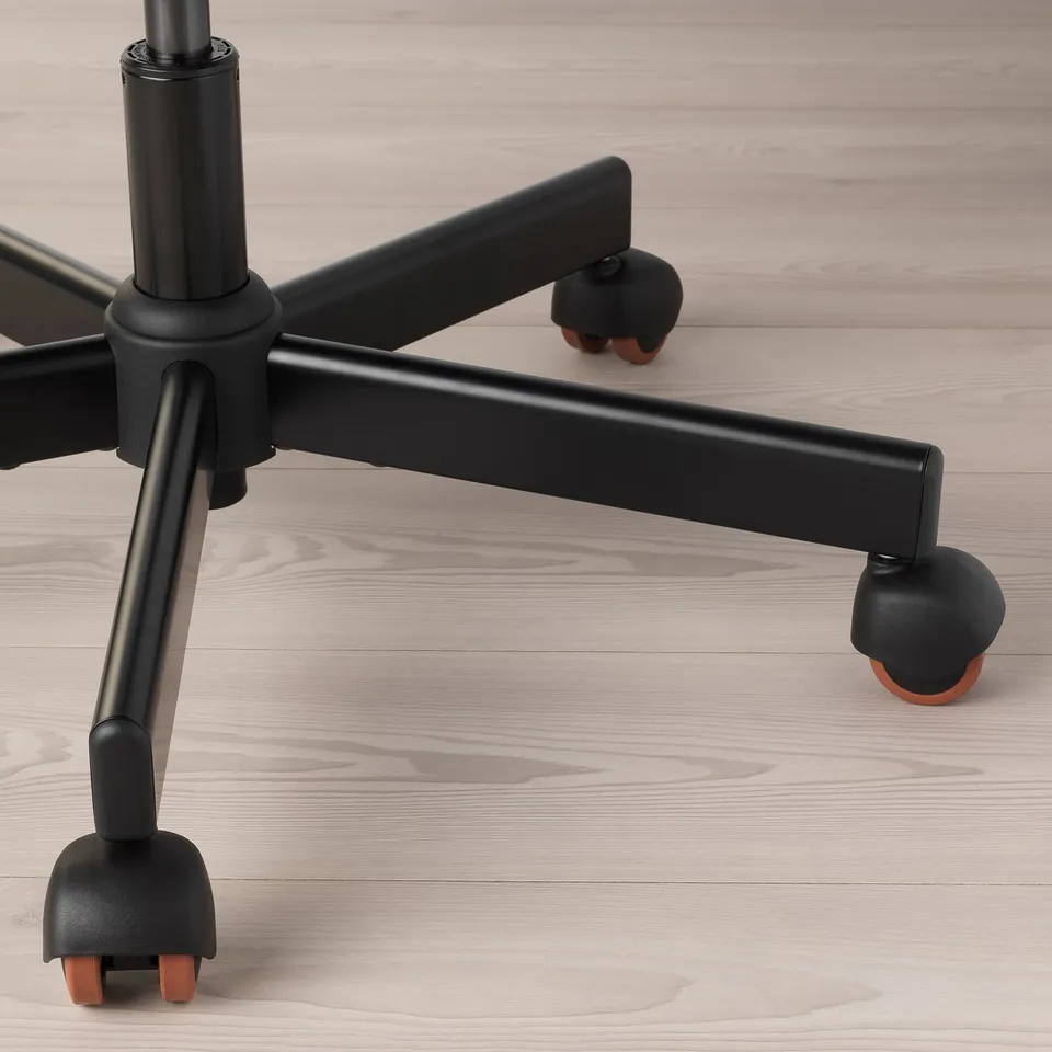 Close-up of an office chairs sturdy base and quality casters on sleek wooden floor.