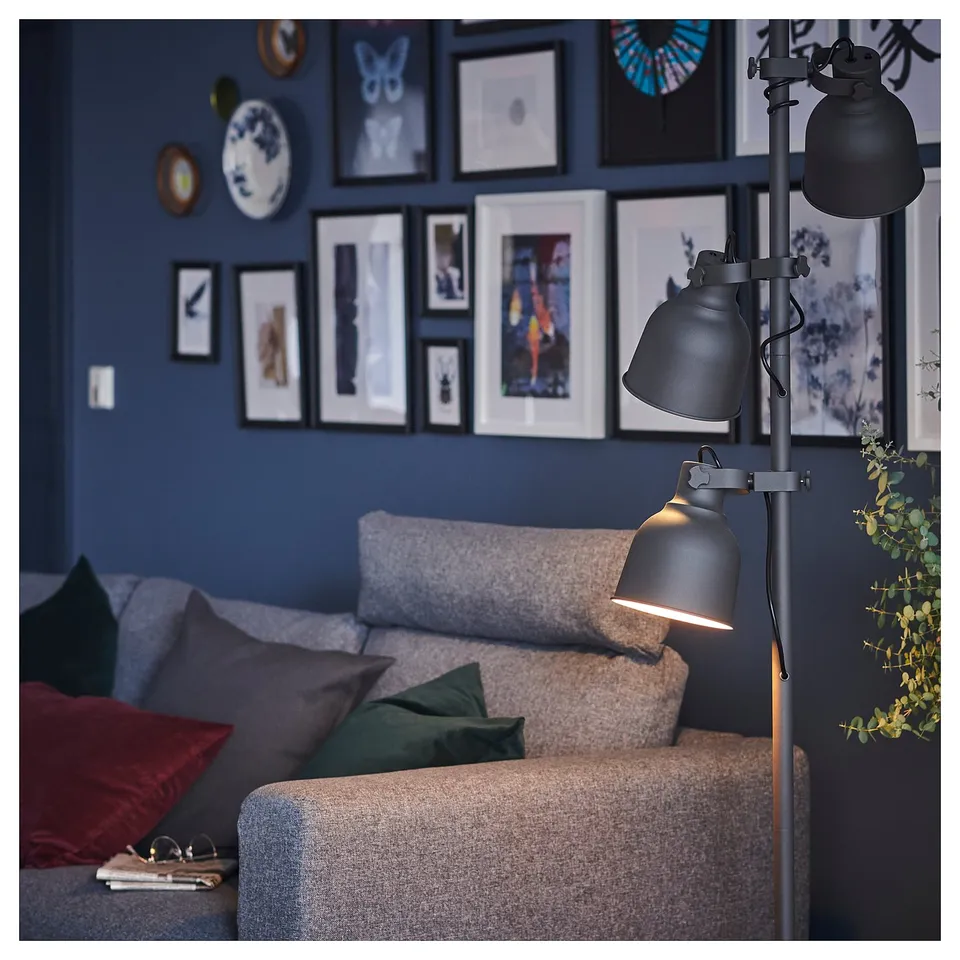 Cosy living room with black lamps, grey sofa, colourful cushions, and framed wall art.