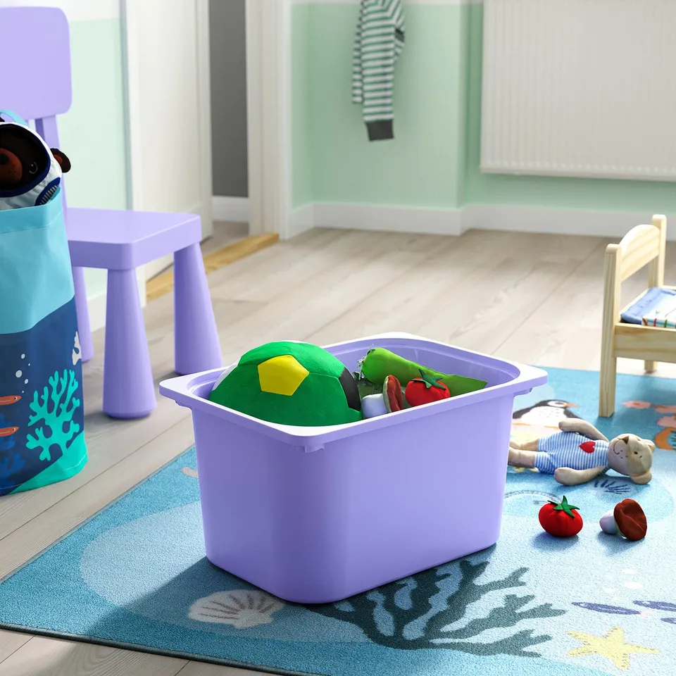 Toy bin with kids toys on blue rug. Green moose hat and more inside.