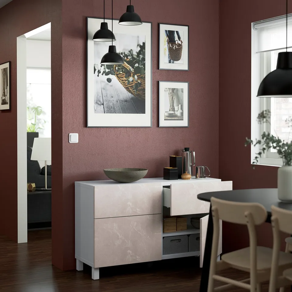 Modern dining room with marble decor, art, and lamps.