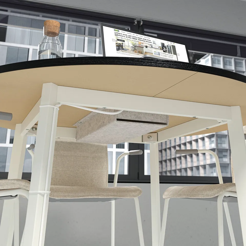 A small round conference table with two chairs, a bottle, and a brochure.